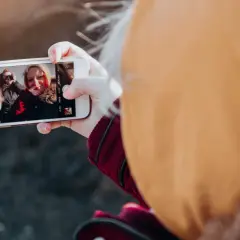 En person tar en selfie med vänner, en bild som visar hur påverkar mobilen oss negativt genom att isolera oss i digitala bubblor.