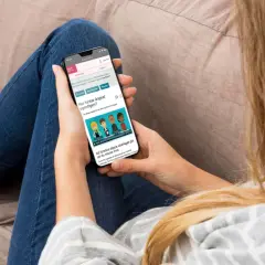 Person läser på mobilen om hur ångest fungerar, kanske för att lära sig mer om kbt ångest.