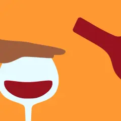 En hand stoppar ett vinglas med rött vin, medan en flaska hälls. Känslan av ångest av alkohol kan vara överväldigande.