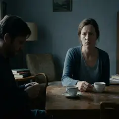 En kvinna och en man sitter vid ett bord med kaffe. Mannen tittar ner, kvinnan ser orolig ut. En känsla av triangulering och narcissism hänger i luften.