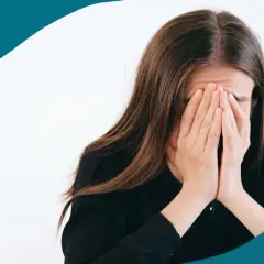 En kvinna med händerna för ansiktet, en bild som kan symbolisera stressrelaterade sjukdomar och känslan av att vara överväldigad.