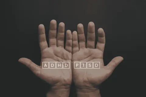 Två öppna händer med texten ADHD och PTSD i rutor. En visuell representation av utmaningar som ptsd svenska kan innebära.