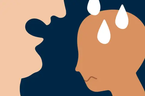 En person med svettpärlor på pannan verkar orolig inför en annan persons uttryck, som kan tolkas som maniskt beteende.