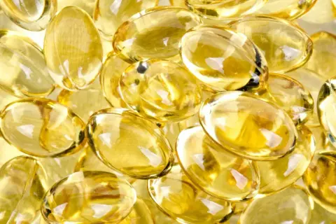 En hög med genomskinliga, gulaktiga kapslar. Dessa kan vara d-vitamin som kan hjälpa mot depression.