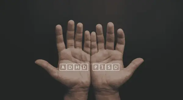 Två öppna händer med texten ADHD och PTSD i rutor. En visuell representation av utmaningar som ptsd svenska kan innebära.
