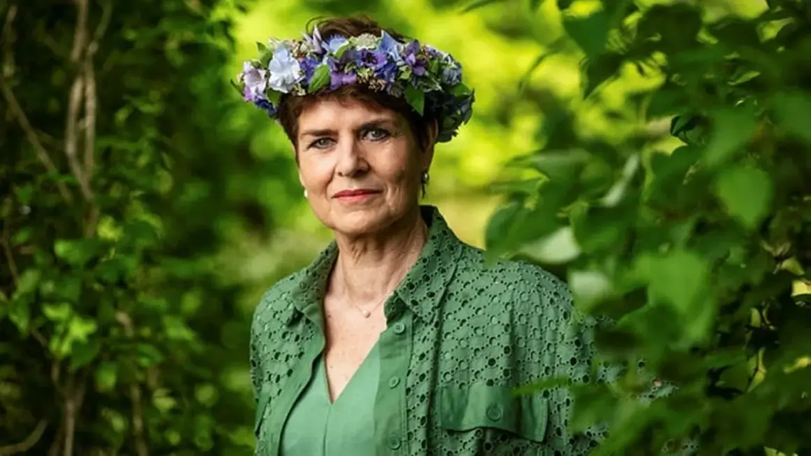 Ullakarin Nyberg med blomsterkrans i grönska.