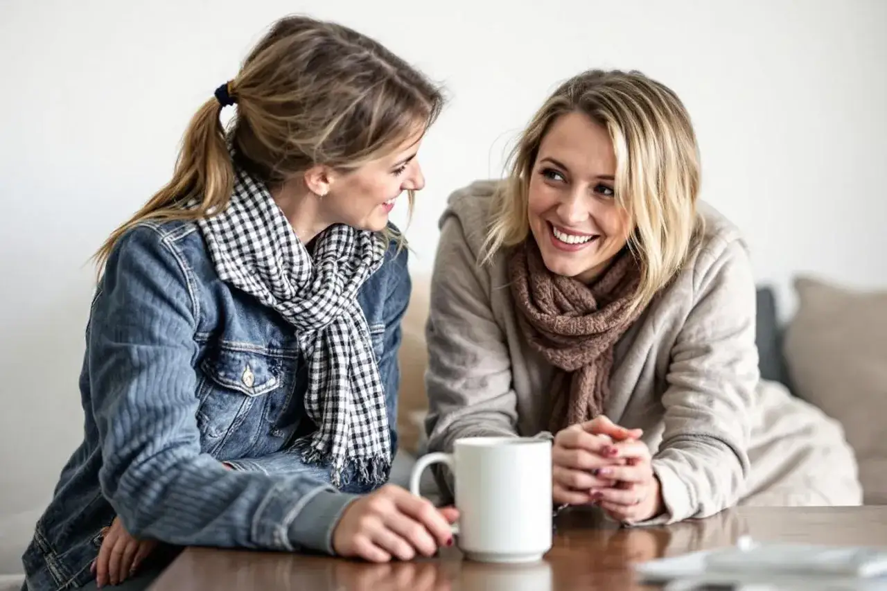 Tv&aring; kvinnor ler mot varandra &ouml;ver en kaffekopp. De har p&aring; sig varma kl&auml;der och halsdukar, en fin p&aring;minnelse om att respektera varandra.