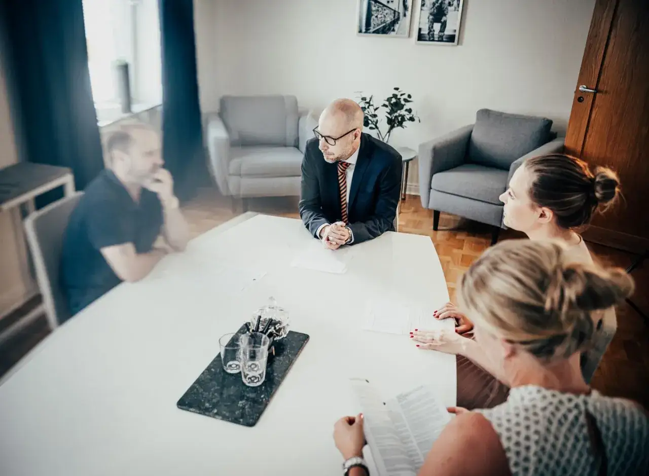 M&ouml;te med en man i kostym vid ett bord. Tv&aring; kvinnor och en man sitter runt bordet. Kanske ett sv&aring;rt samarbetssamtal med narcissist.