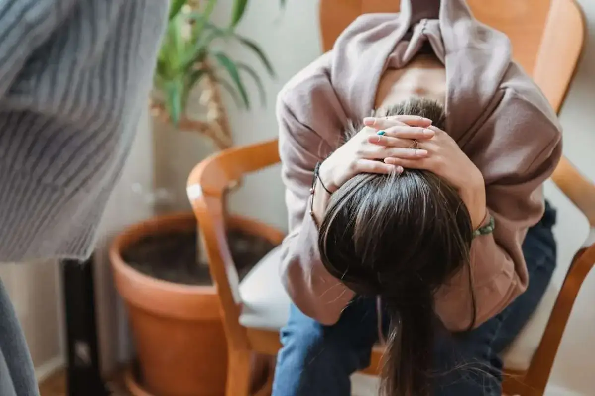 En person sitter med huvudet i h&auml;nderna, en bild som kan symbolisera kampen mot panik&aring;ngest och hur sertralin kan vara en del av l&ouml;sningen.