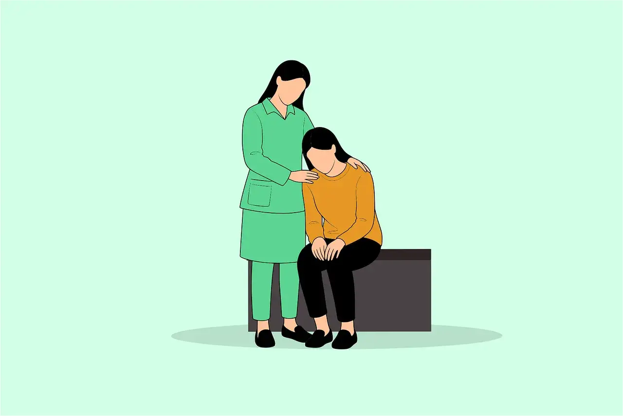 En person i gr&ouml;n uniform tr&ouml;star en annan person som sitter ned. Ett tydligt exempel p&aring; social intelligens och empati.